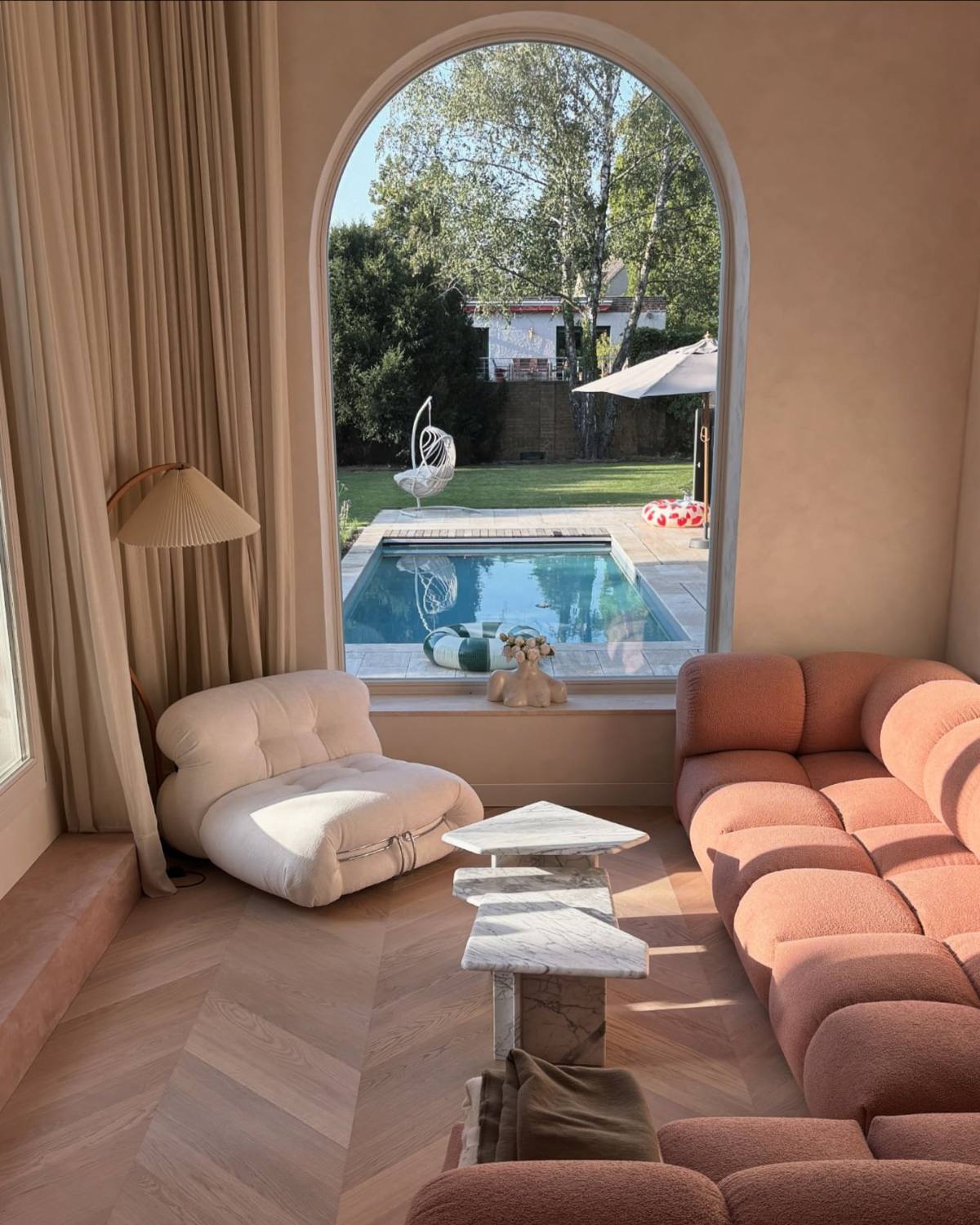 Sanierte Villa in Berlin: Wohnzimmer mit Rundbogenfenster, Kalkputz und Fischgrätparkett